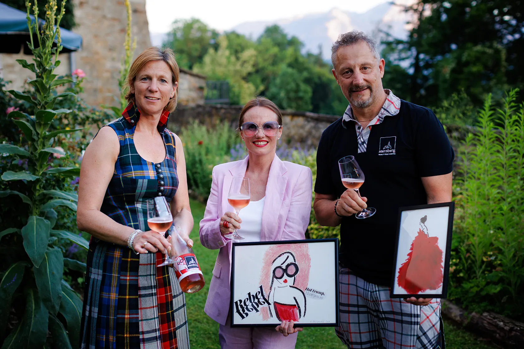 Künstlerin Romy Schwingenschuh präsentiert die Banderole für den Frizzante Rosé 2025. Am Bild v.l.n.r. Petra Egger, Romy Schwingenschuh, Winzer Alexander Egger