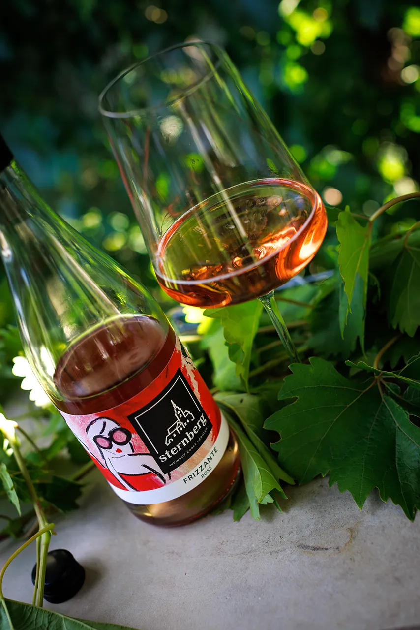Der Frizzante Rosé 2025 mit der von Künstlerin Romy Schwingenschuh gestalteten Banderole.