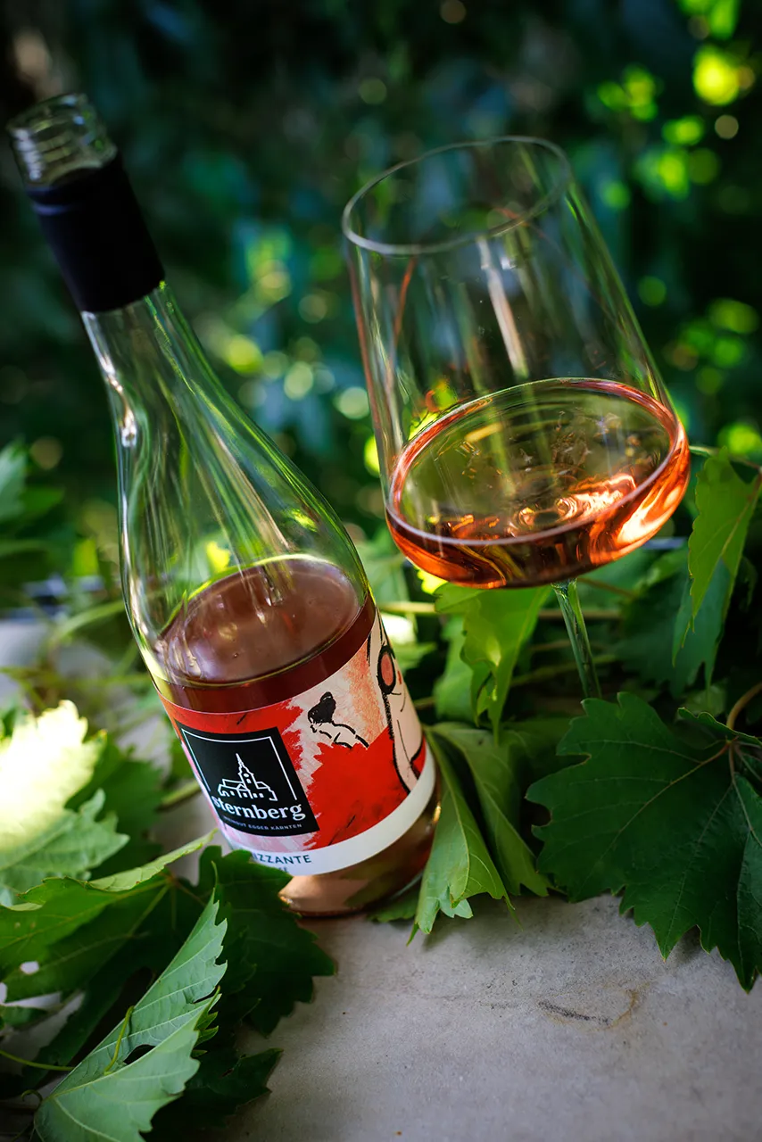 Der Frizzante Rosé 2025 mit der von Künstlerin Romy Schwingenschuh gestalteten Banderole.