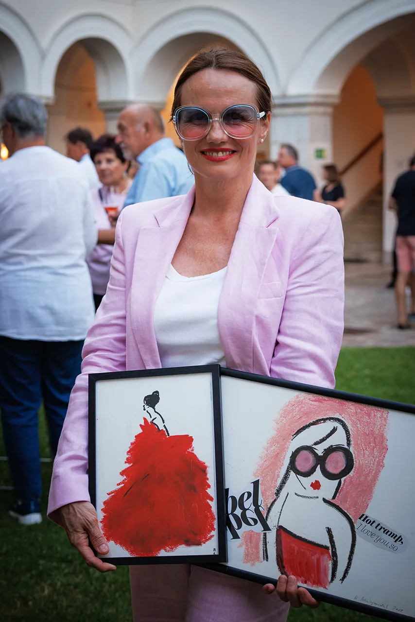 Künstlerin Romy Schwingenschuh präsentiert die Banderole für den Frizzante Rosé 2025.